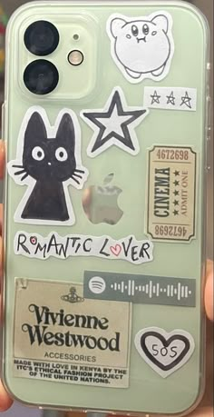 someone is holding up their phone case with stickers on it and some other things