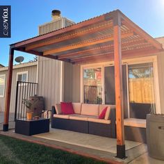 an outdoor living area with couches and a pergolated roof over the patio