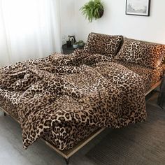 a leopard print comforter on a bed in a room with white walls and flooring