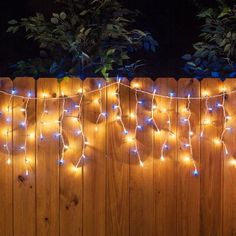 a wooden fence covered in blue and white lights