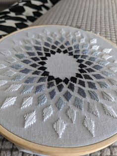 a close up of a circular object on a table cloth with an embroidery pattern in the middle