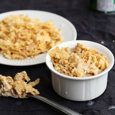 two white bowls filled with food sitting on top of a table next to each other