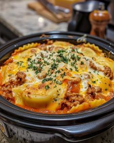 a crock pot filled with meat and cheese