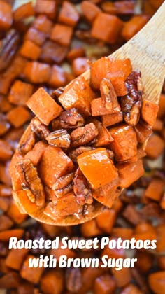 roasted sweet potatoes with brown sugar in a wooden spoon on top of chopped carrots