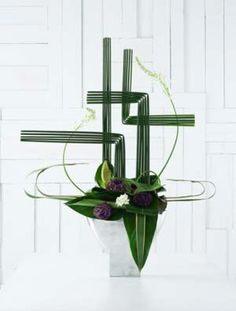 a vase filled with flowers sitting on top of a white table next to a wall