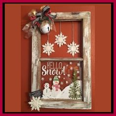 an old window is decorated with snowflakes and a christmas ornament on it