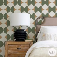 a bed with a lamp on top of it next to a night stand and dresser