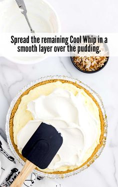 a pie sitting on top of a white counter next to a bowl with whipped cream