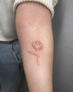 a small sunflower tattoo on the arm