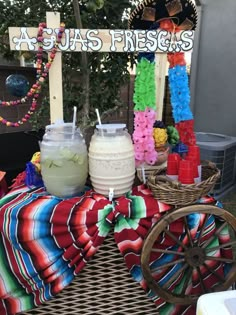 there is a table that has some drinks on it and decorations around the table behind it