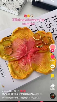 a yellow flower with rings on it sitting on top of a table next to other items