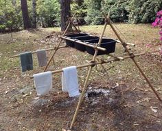 several towels are hanging on a clothes line in the woods with flowers and trees behind them