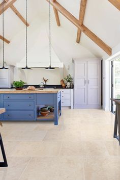 an open kitchen with blue cabinets and wooden beams on the ceiling is shown in this image