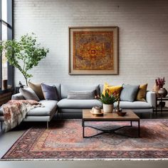 a living room filled with furniture and a large painting hanging on the wall above it