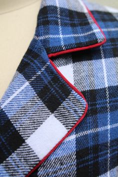 a blue and black plaid jacket with red trim