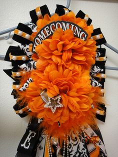 an orange and black wreath hanging on a wall