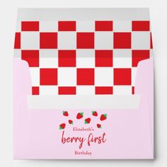 a pink and white checkered envelope with strawberries on the front, in red and white