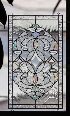 a stained glass window with birds in the center and leaves around it, as well as an ornamental design