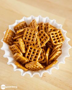 a white bowl filled with pretzels on top of a wooden table