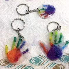 two handprinted glass keychains on a towel