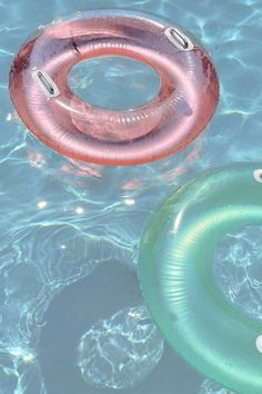 two inflatable rings floating on top of a pool next to another swimming ring