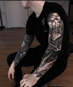 a man sitting on the floor with his arm tattooed