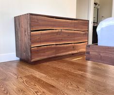 a wooden dresser sitting on top of a hard wood floor