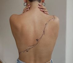 the back of a woman's neck with tattoos on her upper and lower back