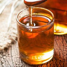 honey being poured into a glass jar