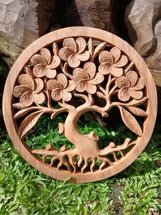 a wooden carving of a tree with leaves in the shape of a bird and flowers