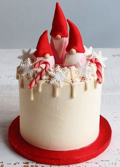 there is a cake with white frosting and red decorations on the top, topped with candy canes