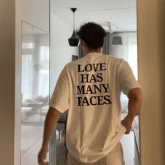 a man wearing a white shirt that says love has many faces