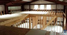 an unfinished room with wooden stairs and windows