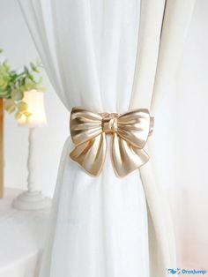 a white curtain with a gold bow on it