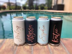 three different types of water bottles sitting next to a swimming pool with the word love on them