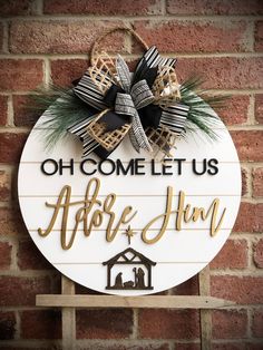 a sign that says, oh come let us adore him with a christmas decoration on it