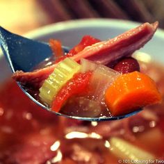 a spoon full of soup with meat and vegetables