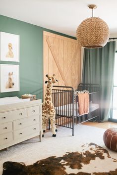 a baby's room with a giraffe stuffed animal in the crib