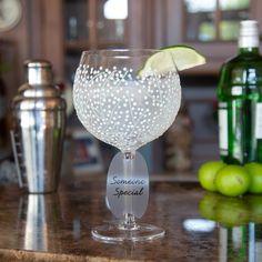 there is a wine glass with a lime in it on the counter next to bottles