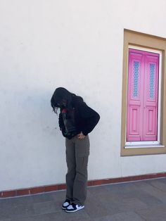 a person standing in front of a pink door