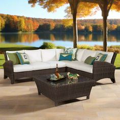 a couch and table on a patio with trees in the backgroung area