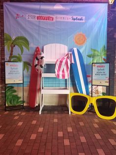 two yellow sunglasses sitting on top of a brick floor next to a surfboard and other items