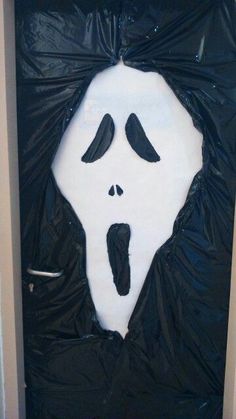 a door decorated to look like a ghost with black and white paint on it's face