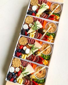 four trays filled with different types of food