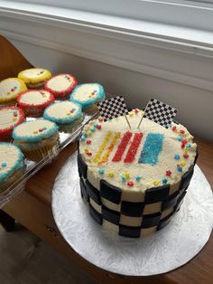 a birthday cake and cupcakes on a table