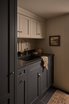 a kitchen area with sink, cabinets and rug on the floor in front of it