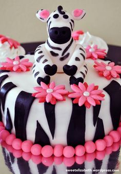 a zebra cake decorated with pink and white flowers