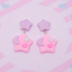 two pink and purple earrings with hearts on them