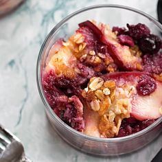 a close up of a bowl of food on a table with a fork and spoon