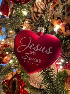 a heart ornament hanging from a christmas tree with ornaments around it and the words jesus my sailor on it